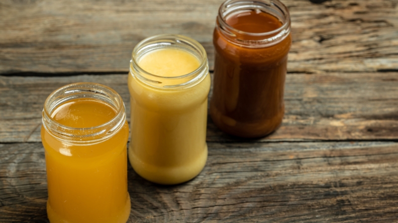 Tri tegle meda različite boje, od svetložute do tamno braon, poređane na drvenom stolu