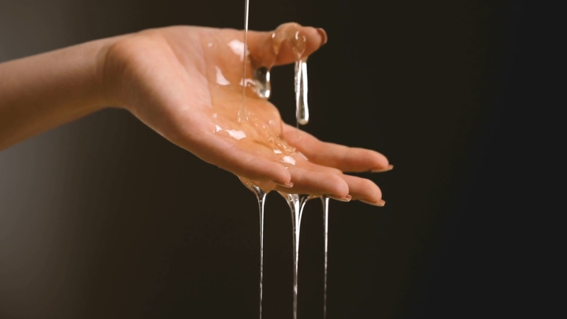 Ruka na koju se polako sliva gust, proziran med